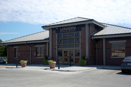 Brick Commercial Buidling with glass entryway with bank signage