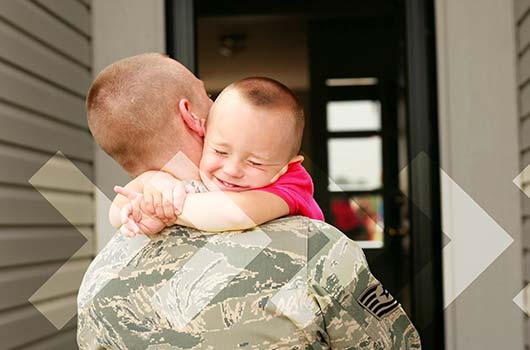 VA Home Loan - A soldier hugging his son as he returns home.