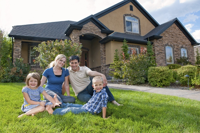 family with two small children sitting on the lawn in front of a