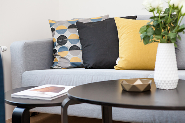 Grey Sofa with Blue and Yellow Pillows, Stylish Coffee Table