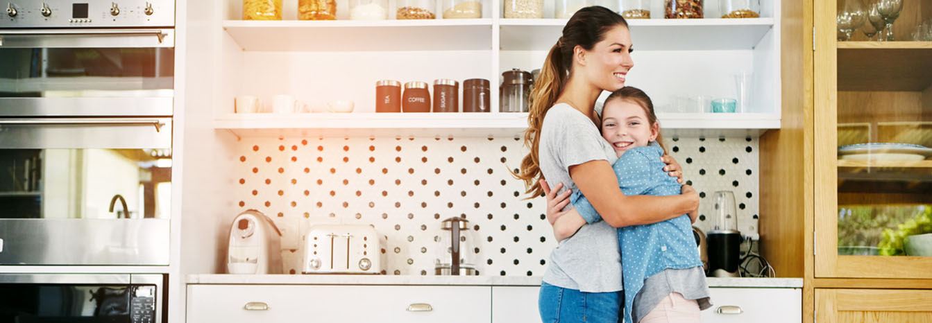 Mom hugging daughter in kitchen