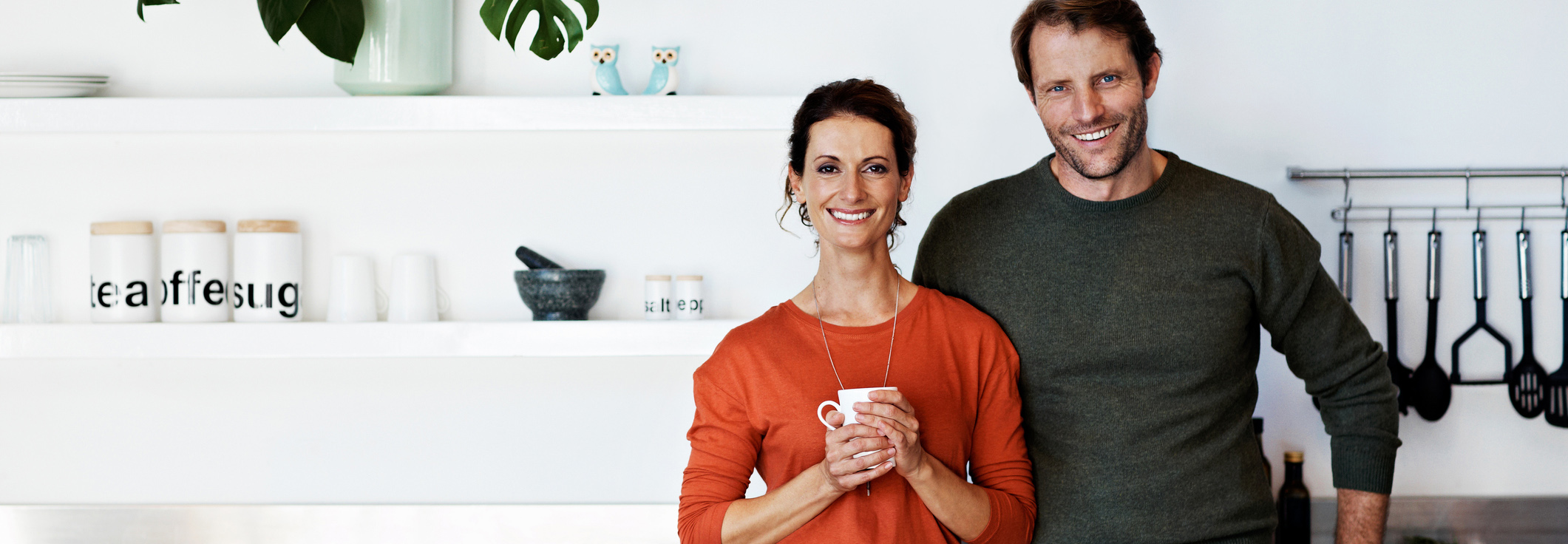 Couple standing in kitchen smiling