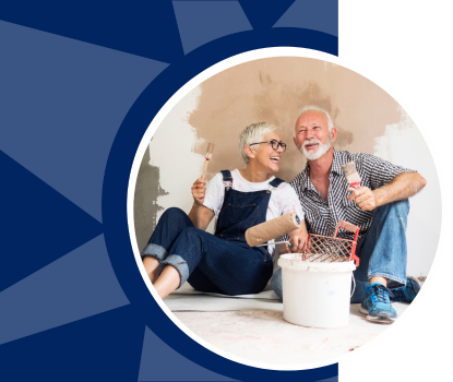 An older couple sits on the floor of a room they are remodeling.
